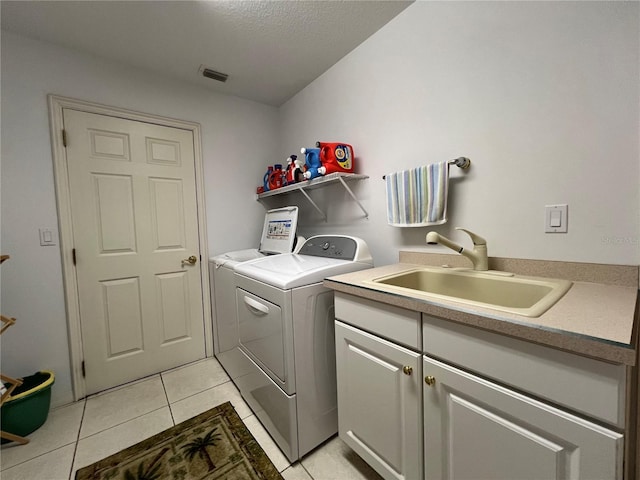 laundry area featuring sink, cabinets, washing machine and clothes dryer, and light tile patterned flooring