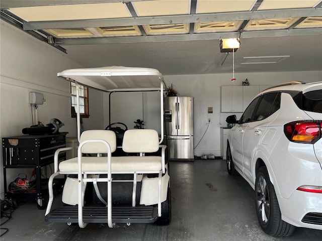 garage featuring a garage door opener and stainless steel fridge