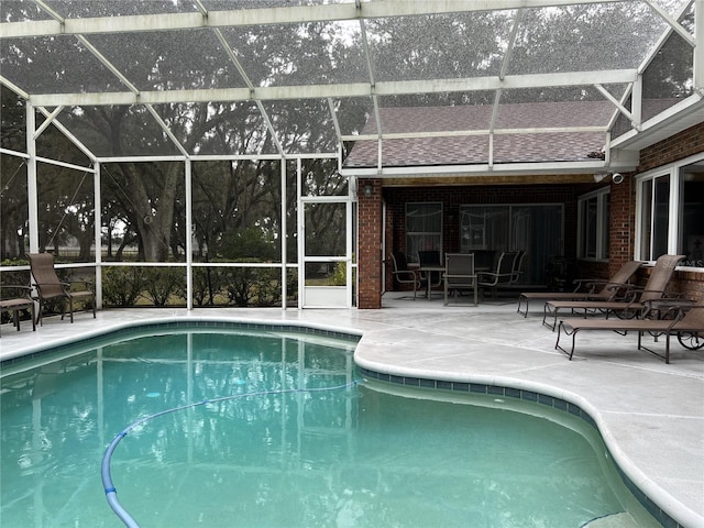 view of pool with a patio and glass enclosure