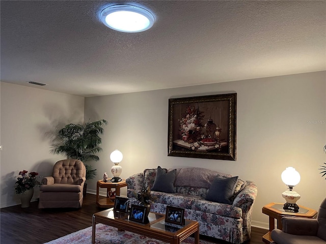 living room with dark hardwood / wood-style flooring and a textured ceiling