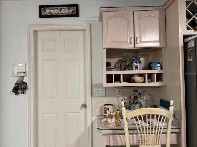 bar featuring refrigerator and light brown cabinetry