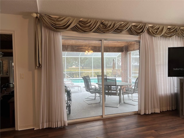 doorway with a healthy amount of sunlight and dark hardwood / wood-style floors