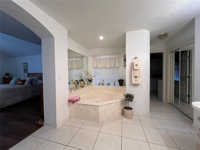 bathroom featuring a textured ceiling, tile patterned floors, and a bathing tub