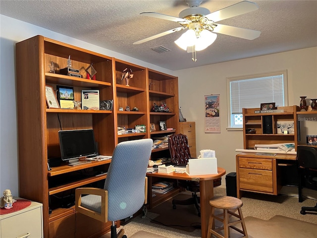 office area featuring ceiling fan, carpet floors, and a textured ceiling