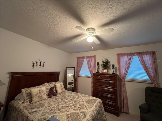 carpeted bedroom with a textured ceiling and ceiling fan