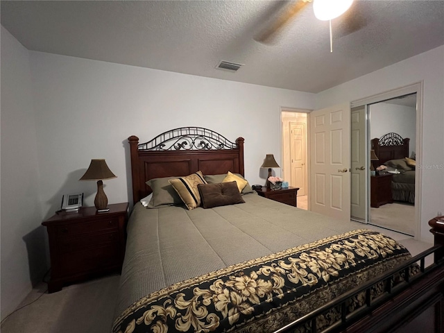 carpeted bedroom with a textured ceiling, a closet, and ceiling fan