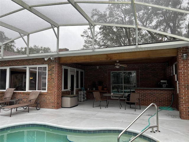 view of swimming pool with ceiling fan, glass enclosure, and a patio