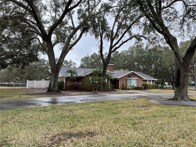 single story home featuring a front lawn