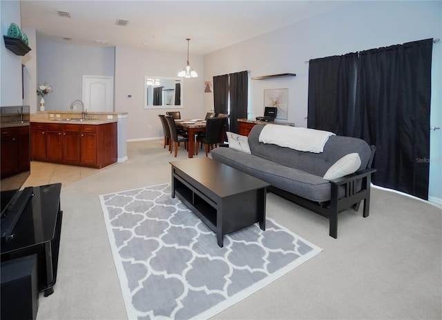 living room with sink, light colored carpet, and an inviting chandelier