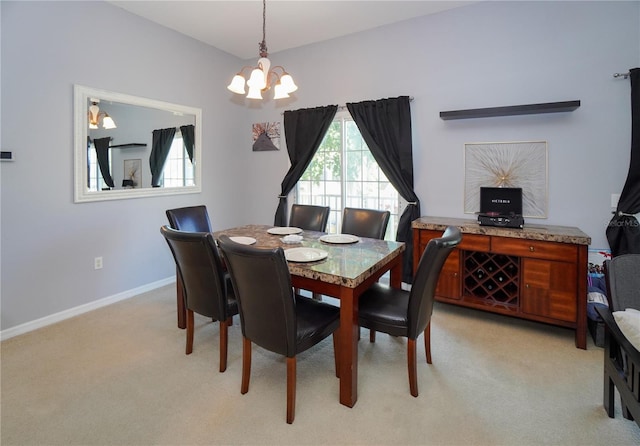 dining space featuring light carpet and an inviting chandelier