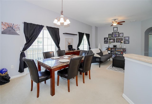 dining room featuring ceiling fan with notable chandelier and light carpet