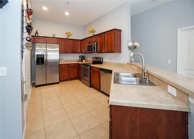 kitchen with sink, kitchen peninsula, stainless steel appliances, and light tile patterned flooring