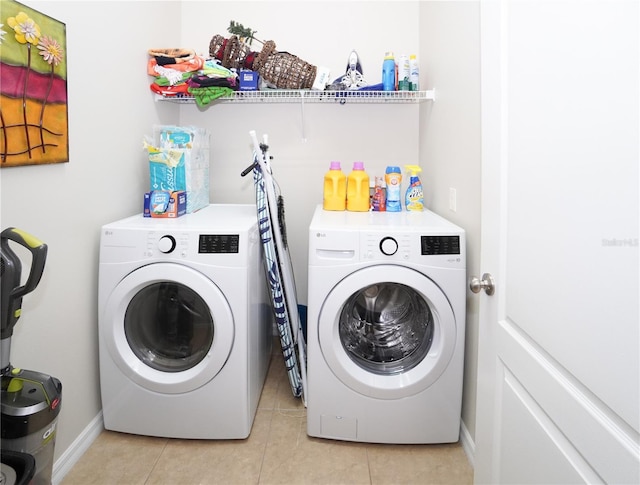 laundry area with light tile patterned flooring and washer and dryer