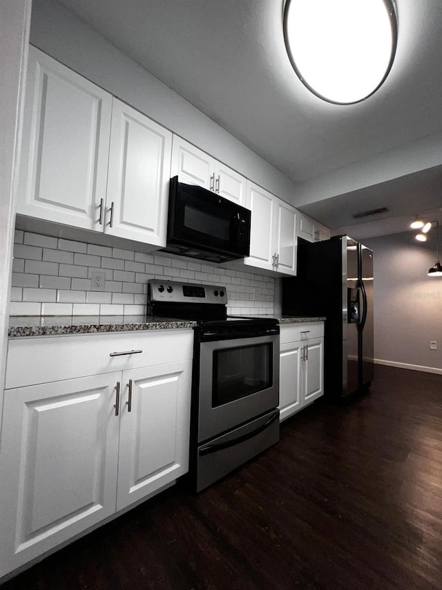 kitchen with white cabinetry, dark stone countertops, appliances with stainless steel finishes, dark hardwood / wood-style floors, and decorative backsplash