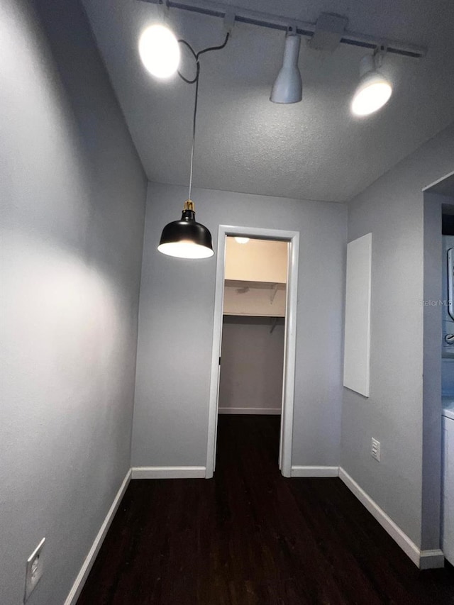 unfurnished dining area featuring rail lighting and dark hardwood / wood-style floors