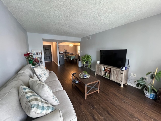 living room with dark wood-type flooring and a textured ceiling