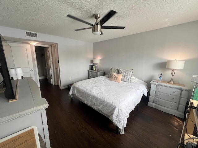 bedroom featuring ceiling fan, a textured ceiling, and dark hardwood / wood-style flooring