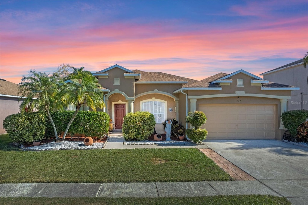 view of front facade with a garage and a lawn