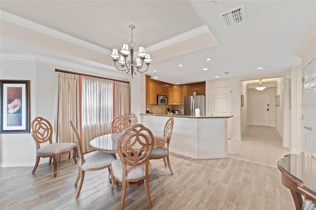 dining space featuring light wood-type flooring, a chandelier, and ornamental molding