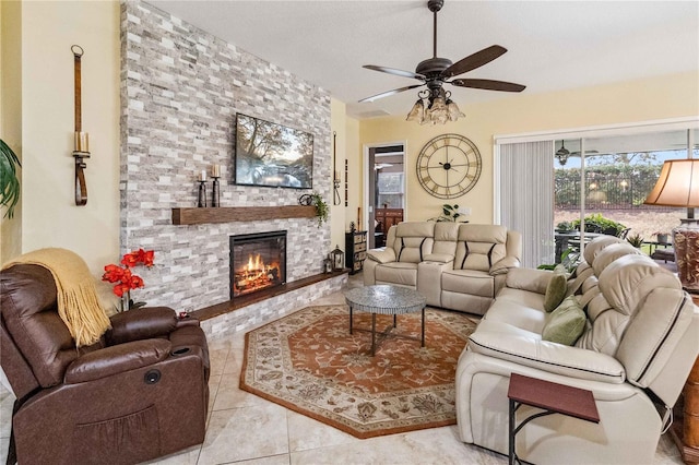 tiled living room featuring ceiling fan and a fireplace