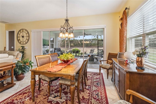 tiled dining room featuring a notable chandelier