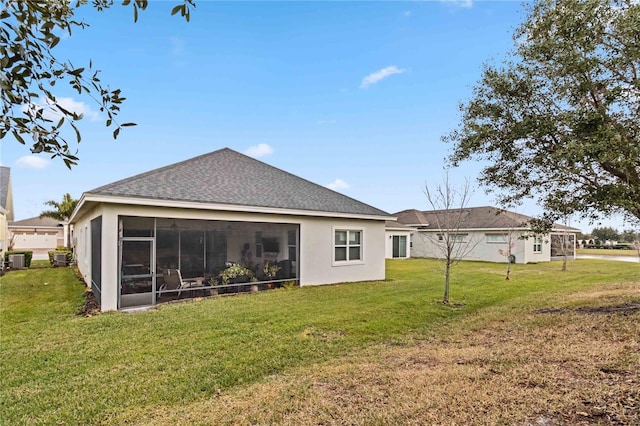 rear view of house featuring a sunroom and a lawn