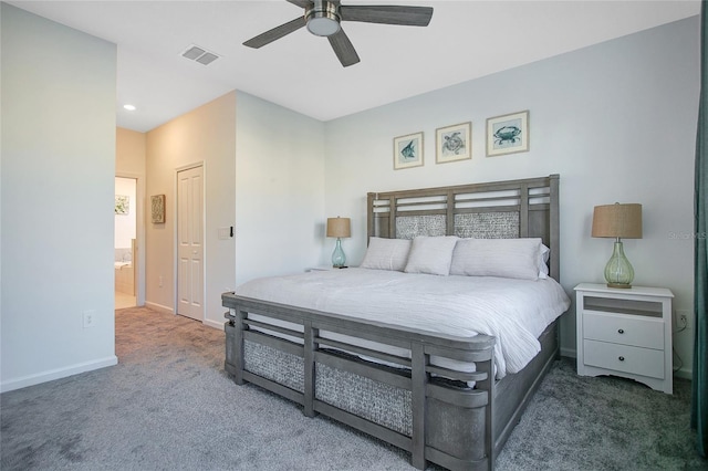 bedroom with dark colored carpet, a closet, ceiling fan, and ensuite bath