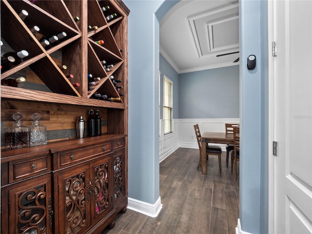 wine room with dark hardwood / wood-style flooring and crown molding