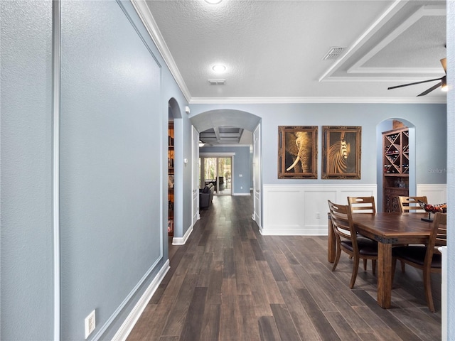 corridor with crown molding, dark hardwood / wood-style floors, and a textured ceiling