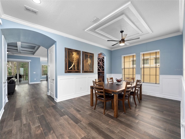 dining space featuring crown molding, dark wood-type flooring, ceiling fan, and a textured ceiling