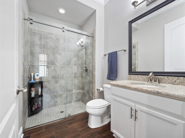 bathroom featuring walk in shower, vanity, and toilet