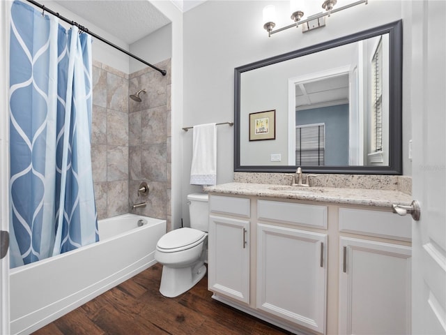 full bathroom featuring shower / tub combo, vanity, wood-type flooring, a textured ceiling, and toilet