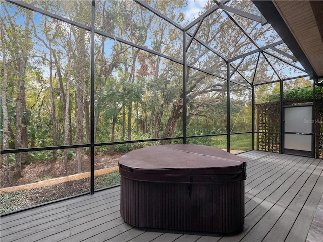 wooden terrace featuring a hot tub and glass enclosure