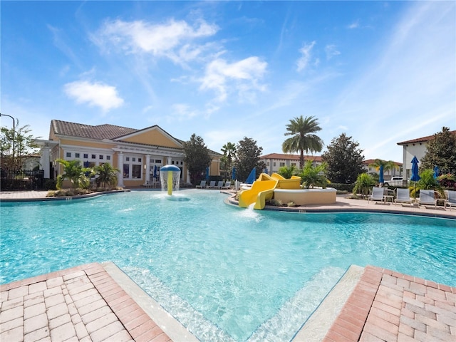 view of swimming pool featuring a patio, pool water feature, and a water slide