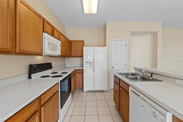 kitchen with sink, white appliances, and light tile patterned floors