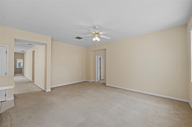 carpeted spare room with a textured ceiling and ceiling fan