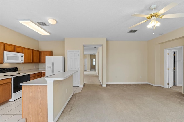 kitchen with ceiling fan, white appliances, a center island, and light carpet