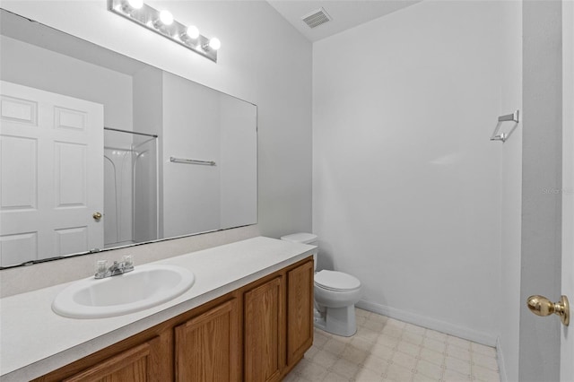 bathroom with vanity, toilet, and a shower