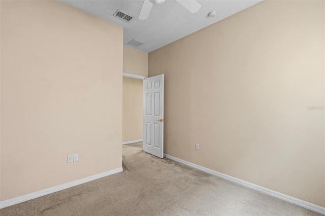 spare room featuring light colored carpet and ceiling fan