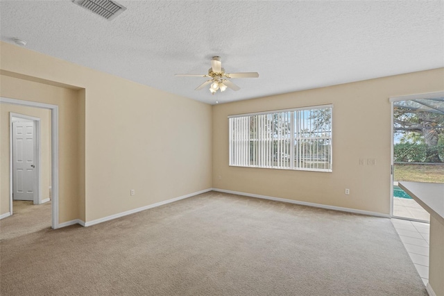 unfurnished room with light colored carpet, a textured ceiling, and ceiling fan