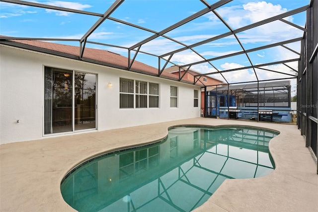 view of swimming pool featuring a patio and glass enclosure