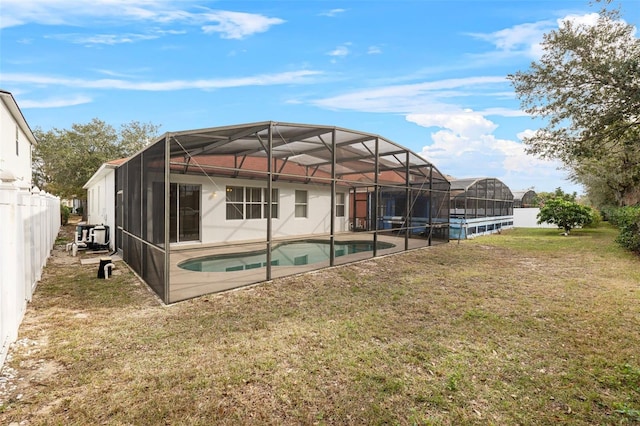 back of house featuring a fenced in pool, a lanai, and a yard