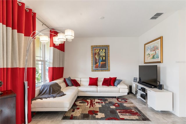 living room with an inviting chandelier and tile patterned flooring