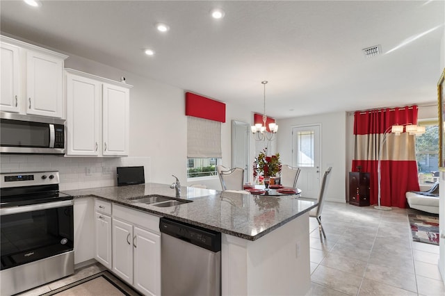 kitchen featuring appliances with stainless steel finishes, sink, white cabinets, and kitchen peninsula