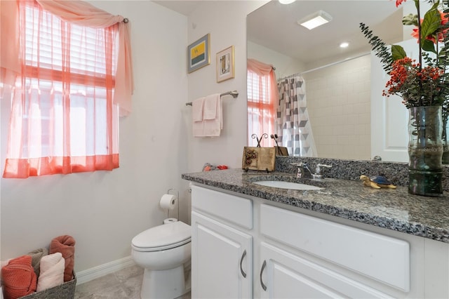 bathroom featuring walk in shower, vanity, toilet, and tile patterned flooring