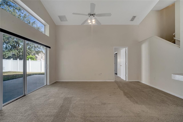 empty room featuring a high ceiling, light carpet, and ceiling fan