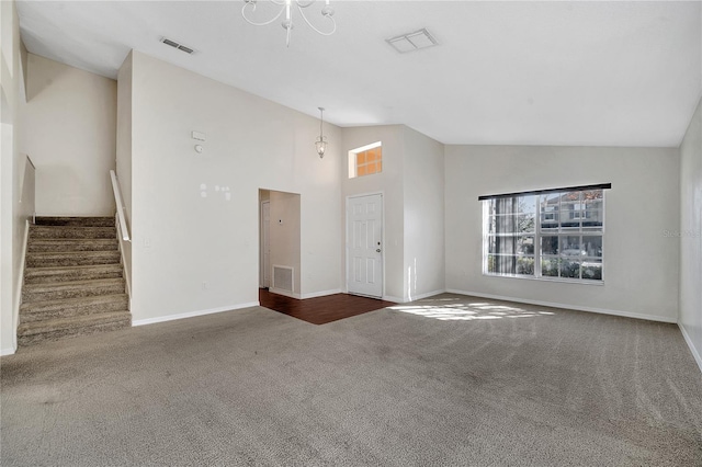 unfurnished living room featuring high vaulted ceiling and dark colored carpet