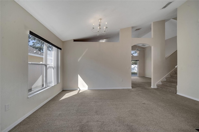 spare room with a chandelier, high vaulted ceiling, and light carpet