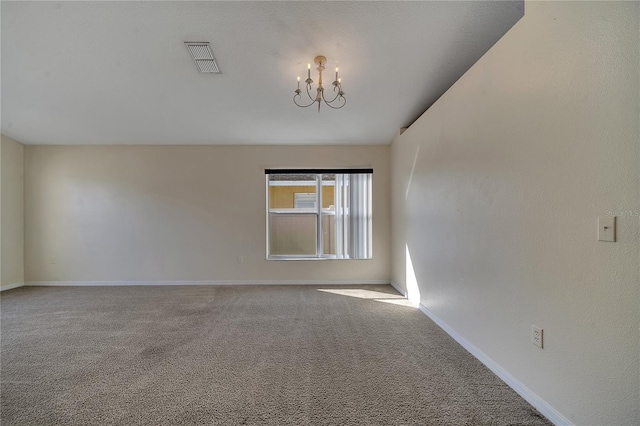 unfurnished room with a chandelier and carpet