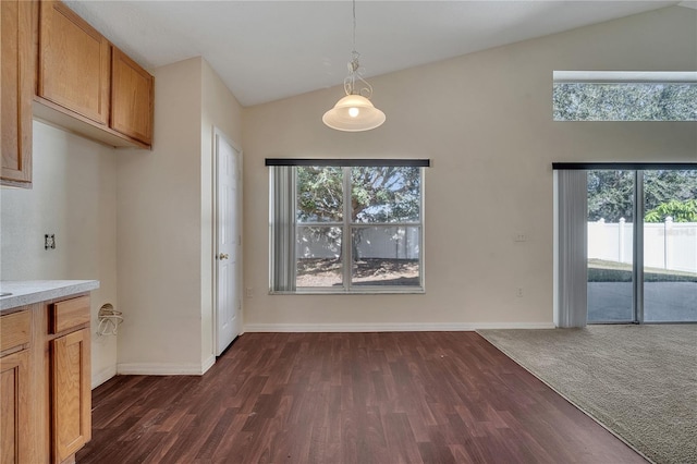 unfurnished dining area with dark wood-type flooring and vaulted ceiling